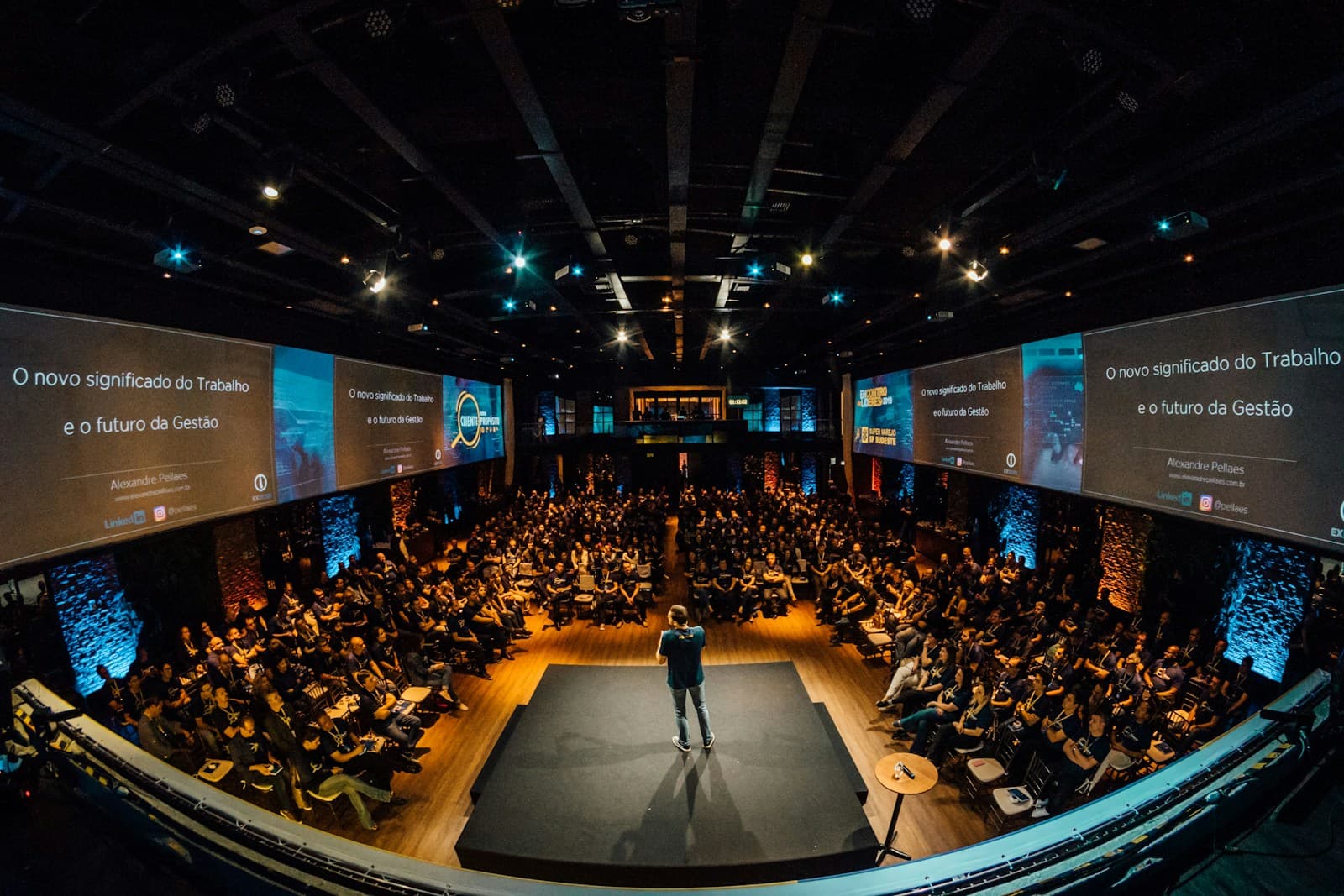 A speaker addressing a large audience from a stage at a technology conference